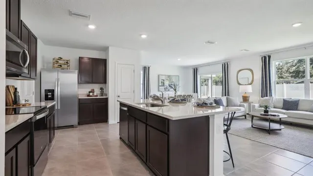 a kitchen with cabinets a sink appliances and living room view