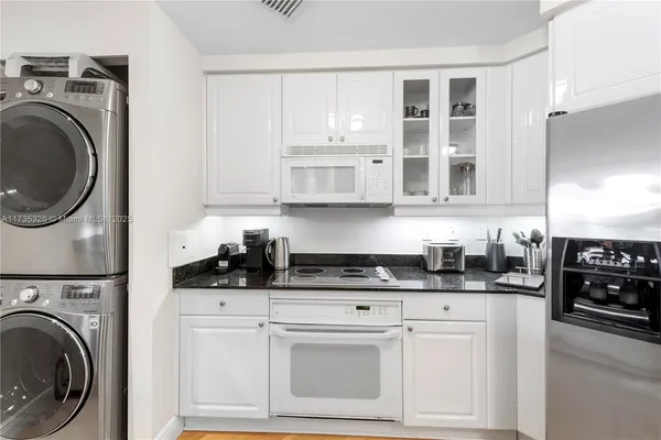 a kitchen with stainless steel appliances granite countertop a sink a stove and cabinets