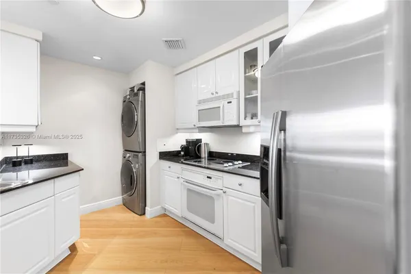 a kitchen with stainless steel appliances granite countertop a refrigerator a stove and a sink