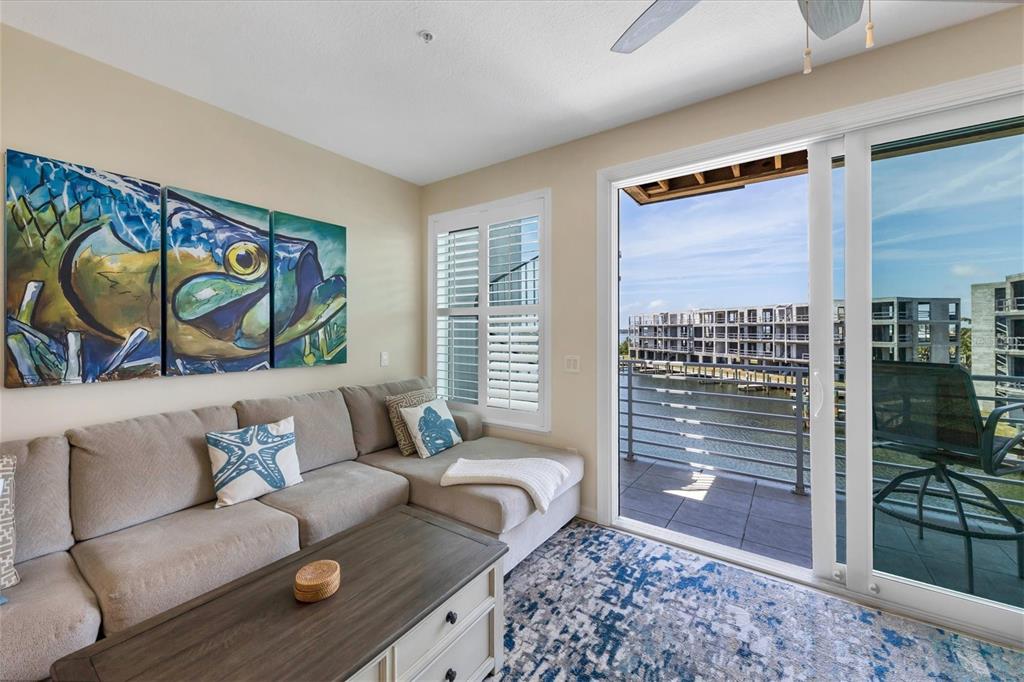 8272 Harborside Circle Englewood, FL 34224 - Photo 29 of 50 a living room with furniture and a floor to ceiling window