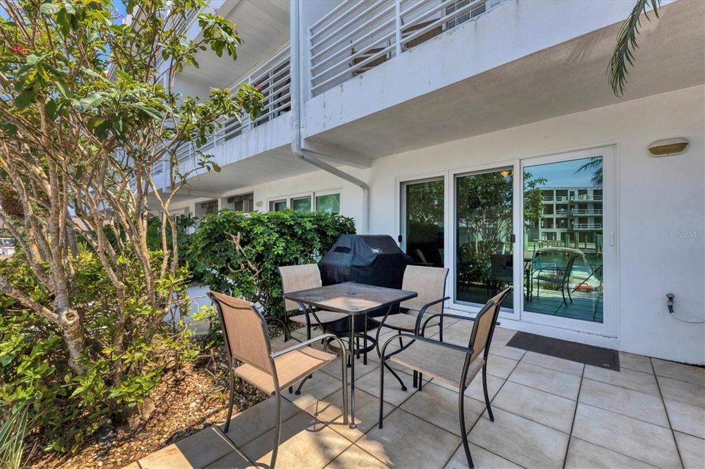 8272 Harborside Circle Englewood, FL 34224 - Photo 39 of 50 a patio with table and chairs and potted plants