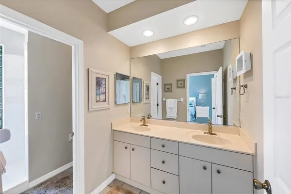 a bathroom with double vanity sinks a mirror and a shower