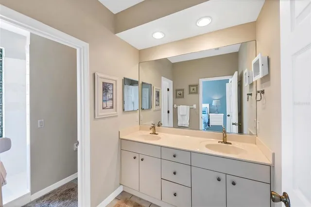 a bathroom with double vanity sinks a mirror and a shower