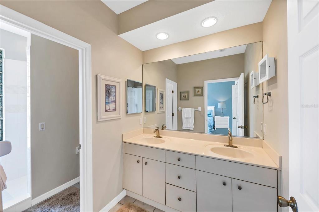 8272 Harborside Circle Englewood, FL 34224 - Photo 5 of 45 a bathroom with double vanity sinks a mirror and a shower