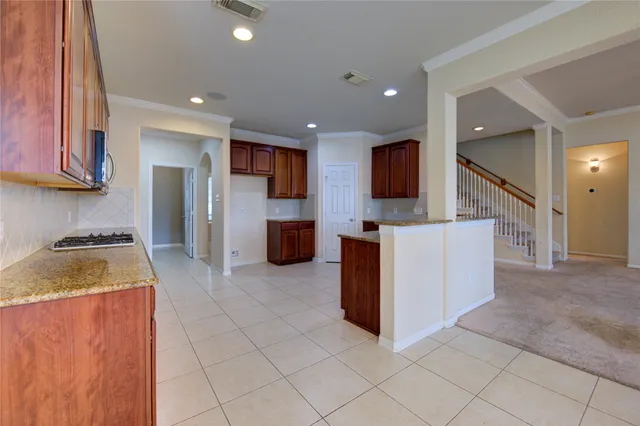 a kitchen with granite countertop a stove a sink and a cabinets
