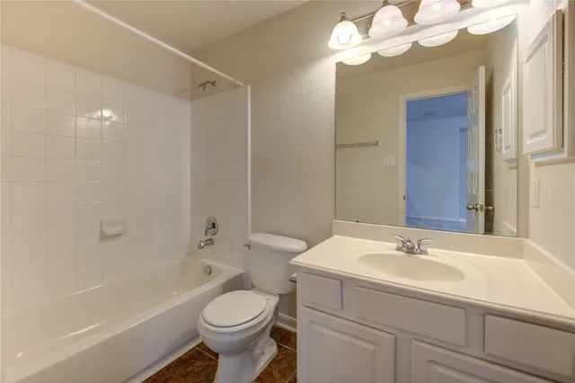 a view of an empty room with a chandelier fan