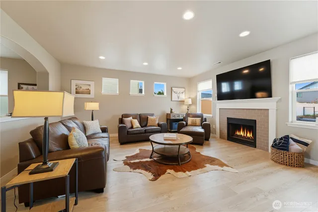 a living room with furniture a fireplace and a flat screen tv