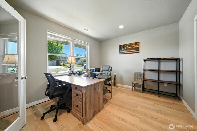 a view of a workspace with furniture and a window