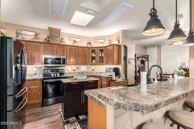 a kitchen with stainless steel appliances granite countertop a sink a stove and a refrigerator
