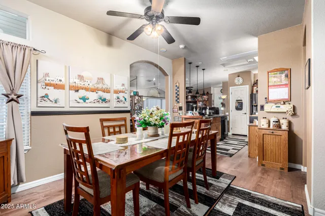 a view of a dining room with furniture and a chandelier fan