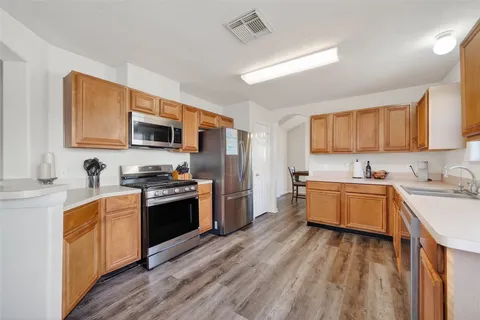 a large kitchen with stainless steel appliances granite countertop a stove refrigerator sink and cabinets