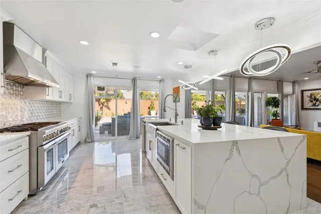 a large kitchen with stainless steel appliances granite countertop a lot of counter space and a sink