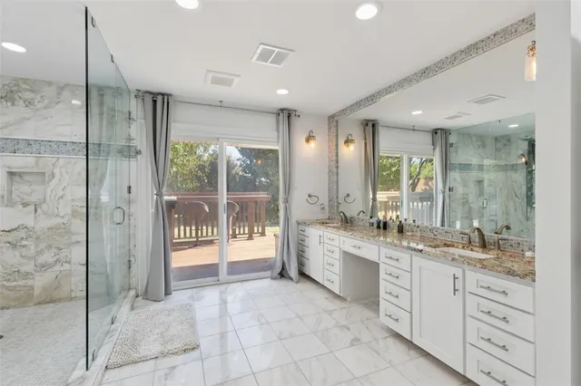 a large bathroom with a glass door shower and sink