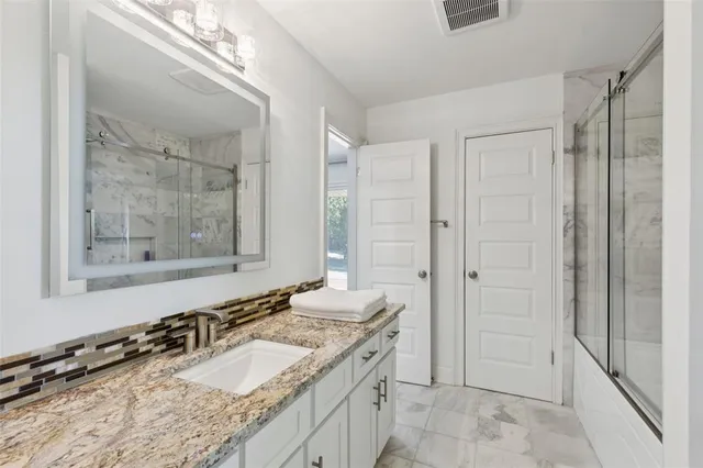 a bathroom with a granite countertop sink mirror and a
