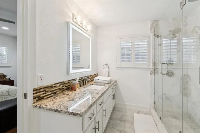 a bathroom with a granite countertop sink and a mirror
