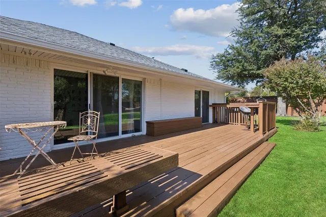a view of a patio with table and chairs with wooden floor and fence