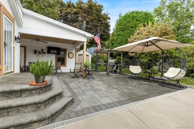 a view of a house with backyard and sitting area