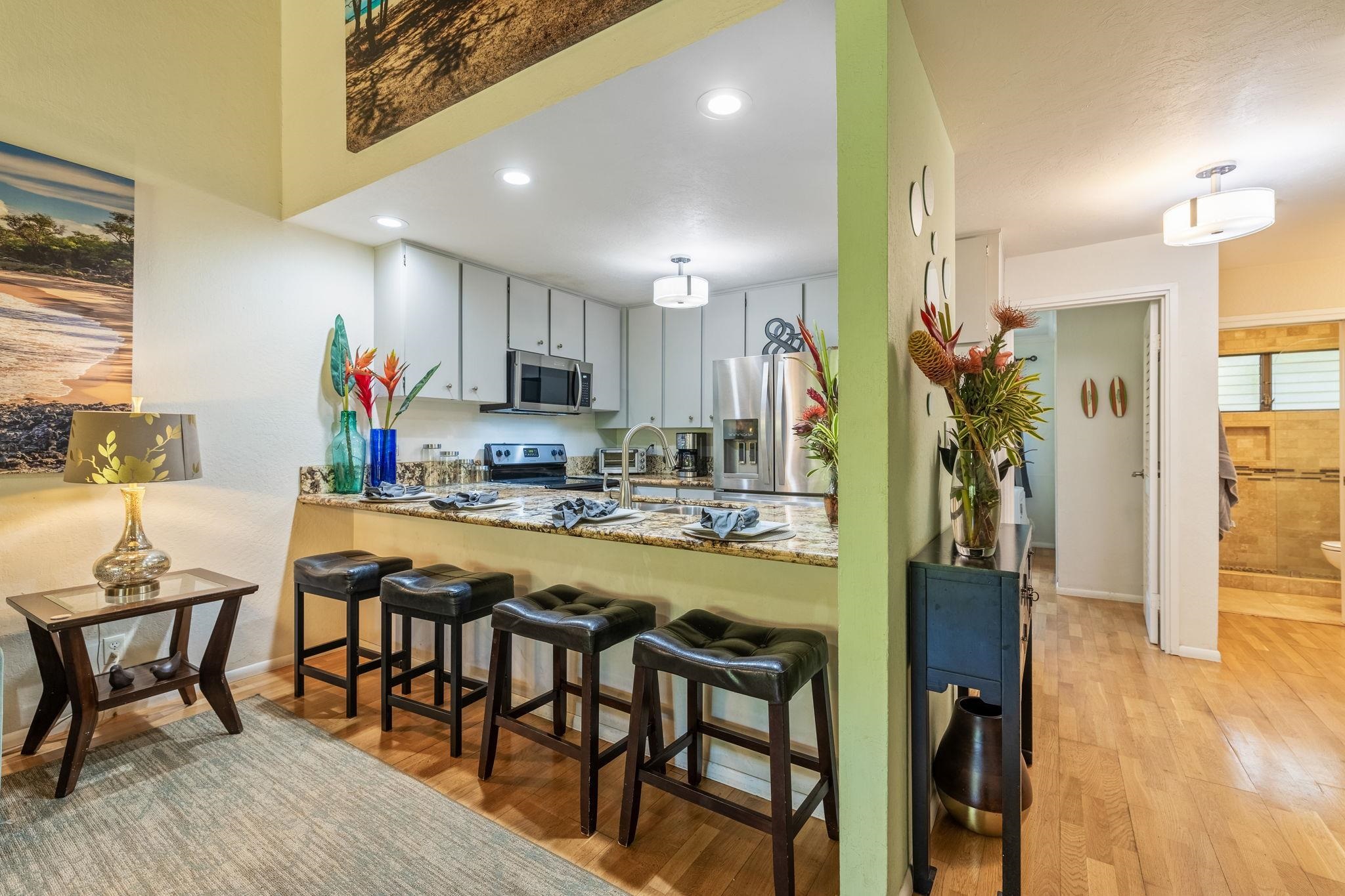 777 South Kihei Road, Unit 221G Kihei, HI 96753 - Photo 12 of 50 a kitchen with stainless steel appliances granite countertop dining table chairs and a refrigerator