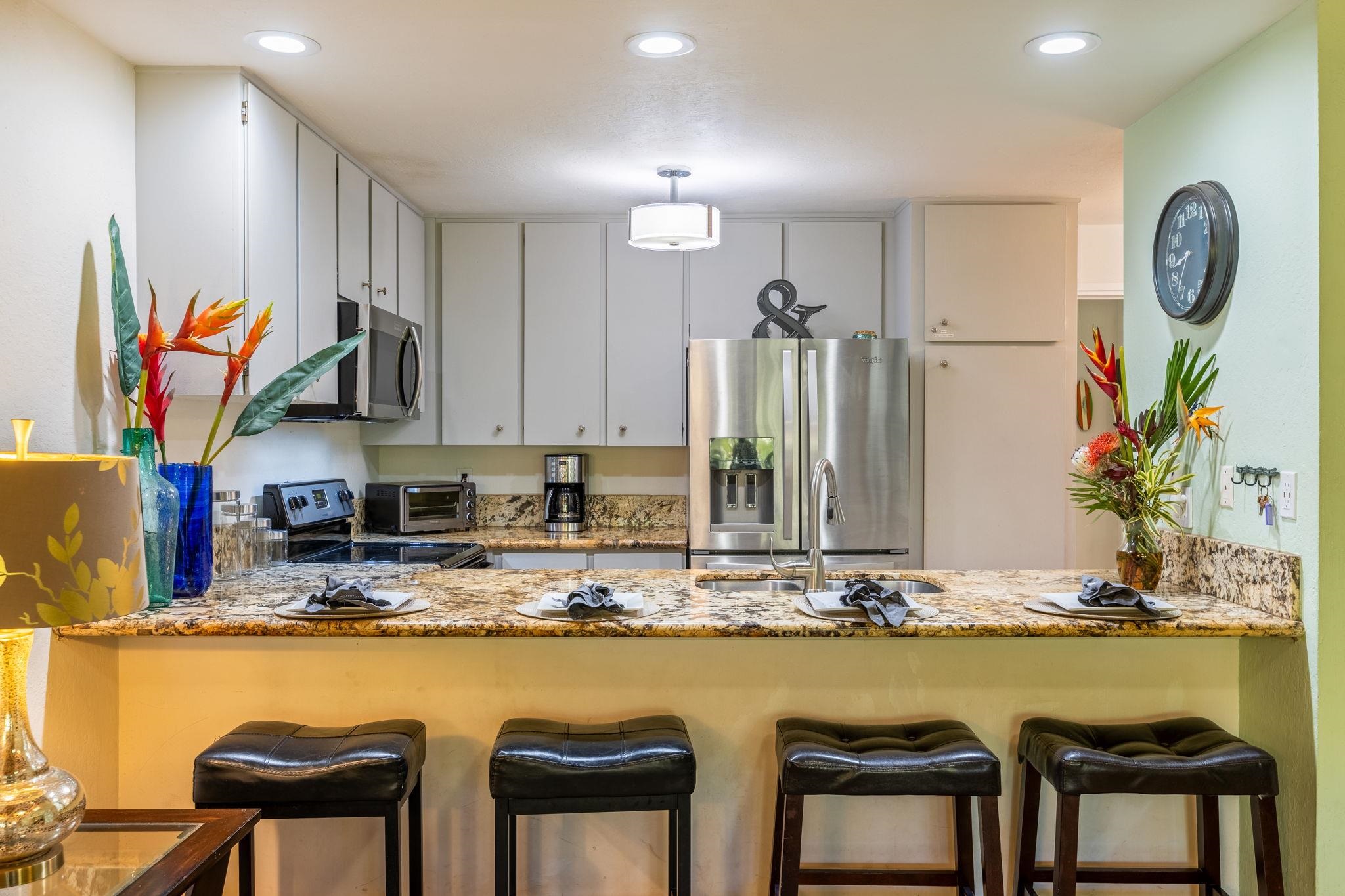777 South Kihei Road, Unit 221G Kihei, HI 96753 - Photo 13 of 50 a view of a kitchen with kitchen island granite countertop a table and chairs in it