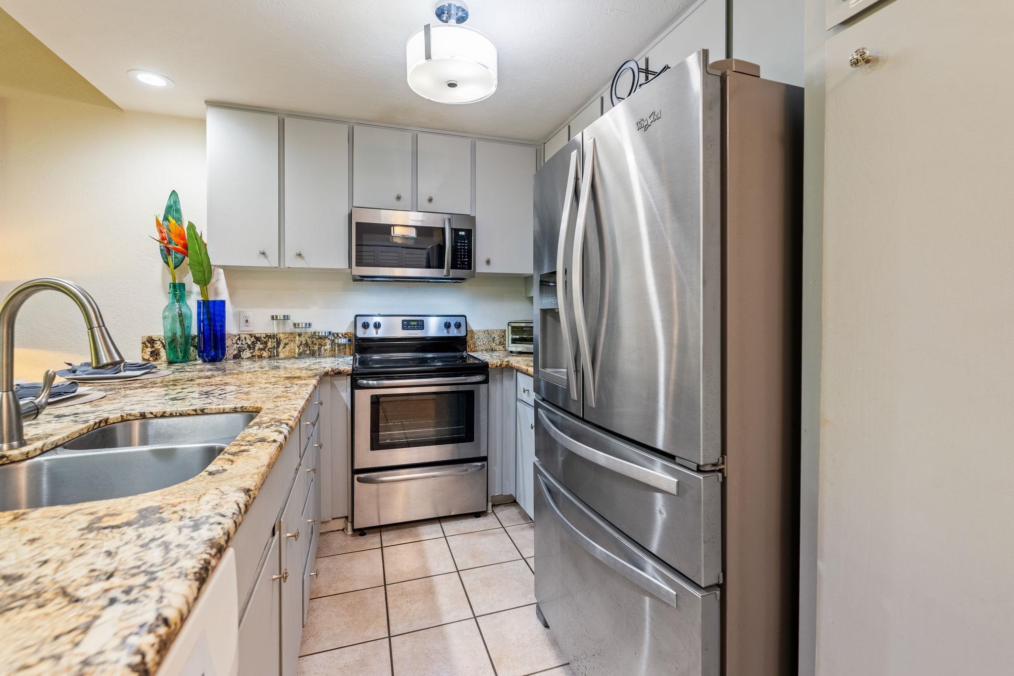 777 South Kihei Road, Unit 221G Kihei, HI 96753 - Photo 10 of 50 a kitchen with granite countertop a refrigerator and a sink