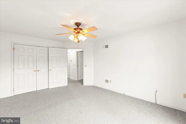 an empty room with a bathroom and a window