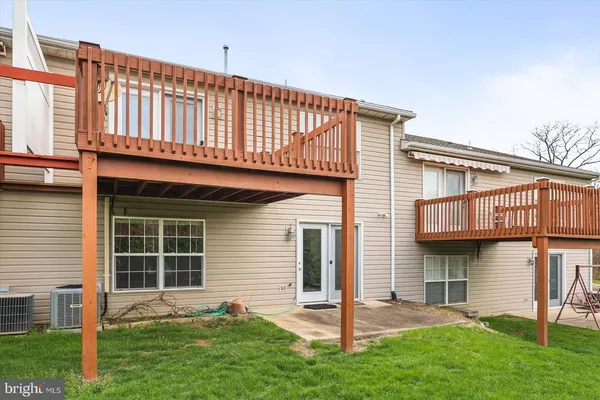 a view of a deck with a big yard potted plants and large tree