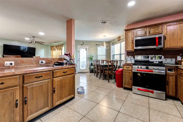 a kitchen with stainless steel appliances kitchen island granite countertop a sink and cabinets