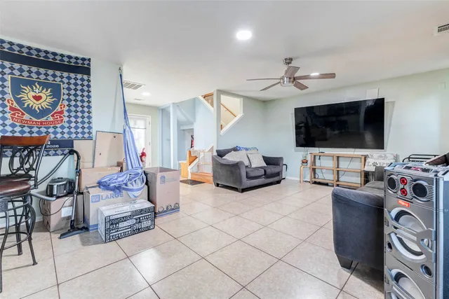 a living room with furniture a flat screen tv and gym equipment