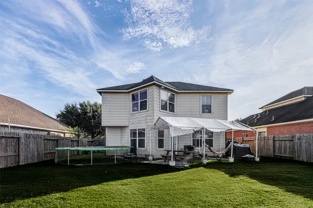 a view of a white house with a yard patio and swimming pool