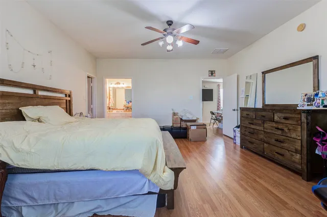 a bedroom with a bed and wooden floor