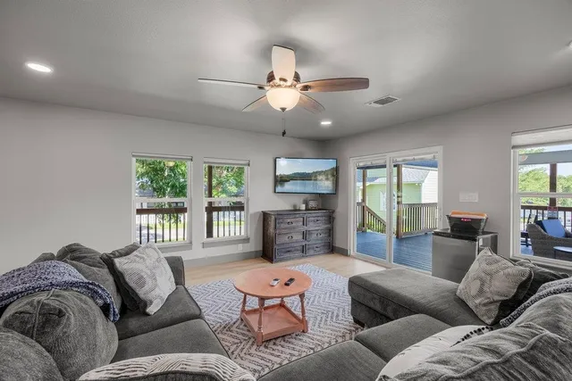 a living room with furniture a large window and flat screen tv