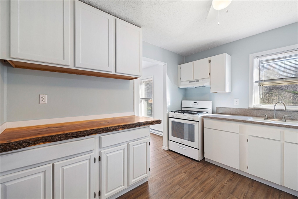 359 Bemis Road Warren, MA 01585 - Photo 14 of 27 a kitchen with granite countertop white cabinets and white appliances