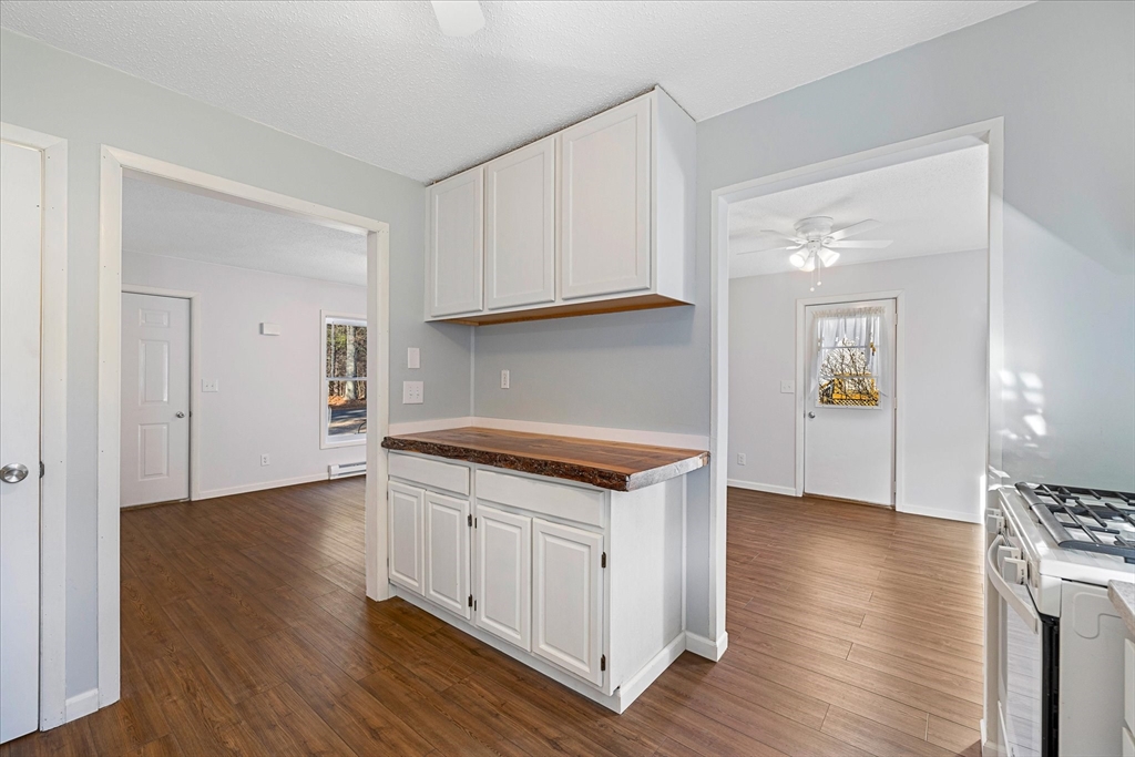 359 Bemis Road Warren, MA 01585 - Photo 16 of 27 a kitchen with granite countertop a stove and a wooden floors