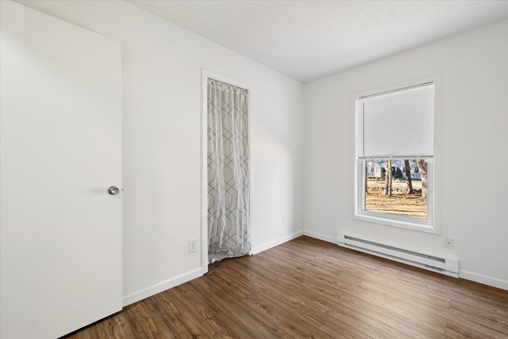 359 Bemis Road Warren, MA 01585 - Photo 17 of 27 an empty room with wooden floor and window
