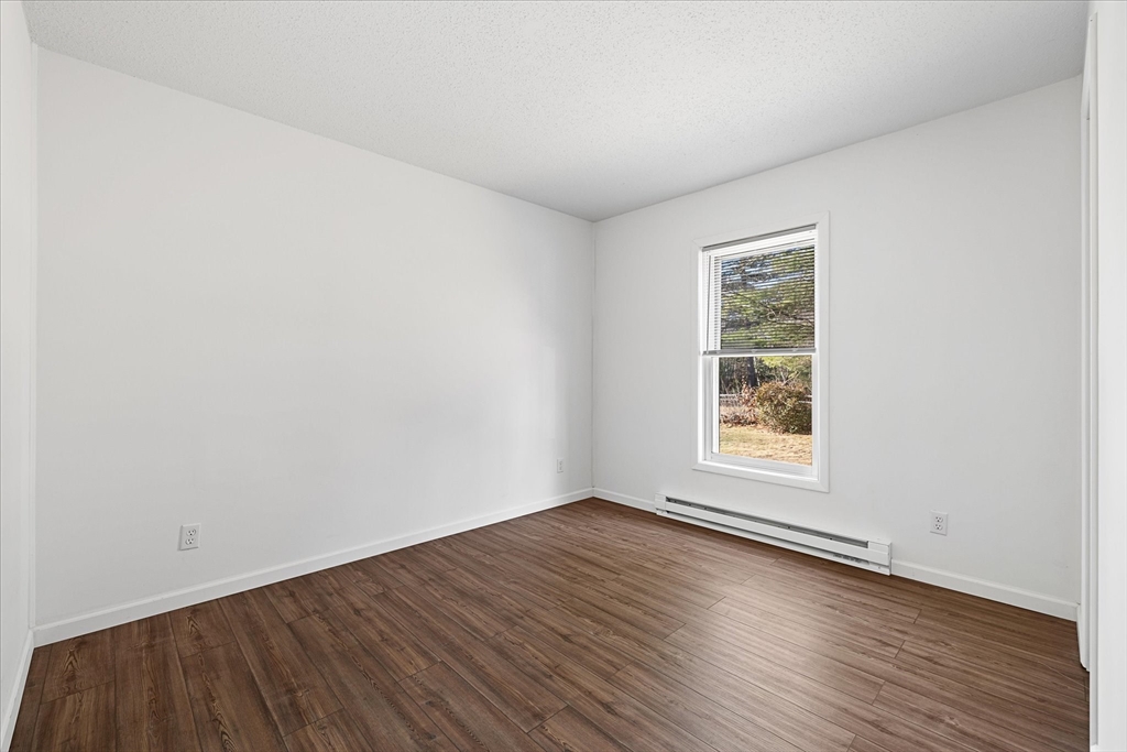 359 Bemis Road Warren, MA 01585 - Photo 19 of 27 an empty room with wooden floor and windows