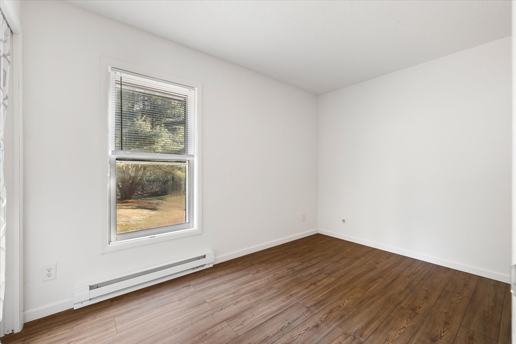 359 Bemis Road Warren, MA 01585 - Photo 21 of 27 an empty room with wooden floor and a window