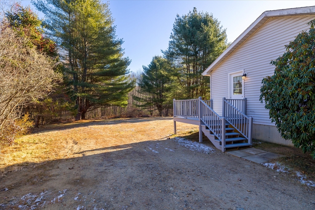 359 Bemis Road Warren, MA 01585 - Photo 3 of 27 a view of a backyard with a large tree and wooden fence
