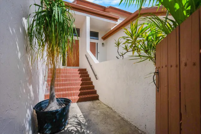 a vase of flowers sitting on a floor in front of a door