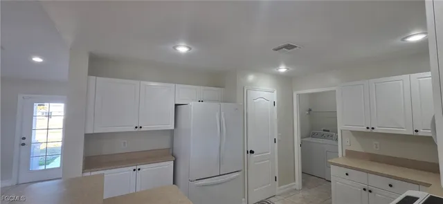 a view of a kitchen with a refrigerator and cabinets