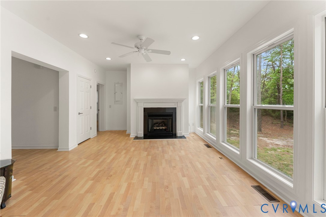 625 Whispering Pines Road Lancaster, VA 22503 - Photo 11 of 71 a view of an empty room with a fireplace and a window