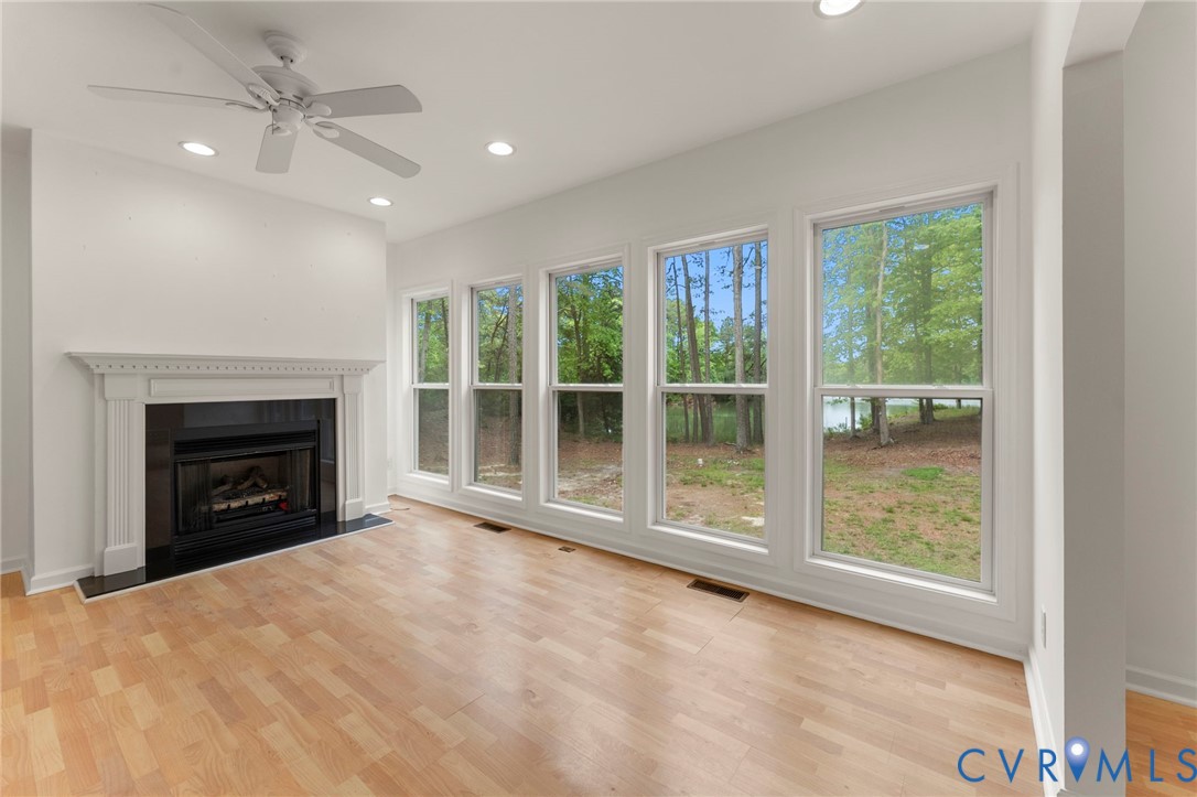 625 Whispering Pines Road Lancaster, VA 22503 - Photo 12 of 71 a view of an empty room with a fireplace and a window