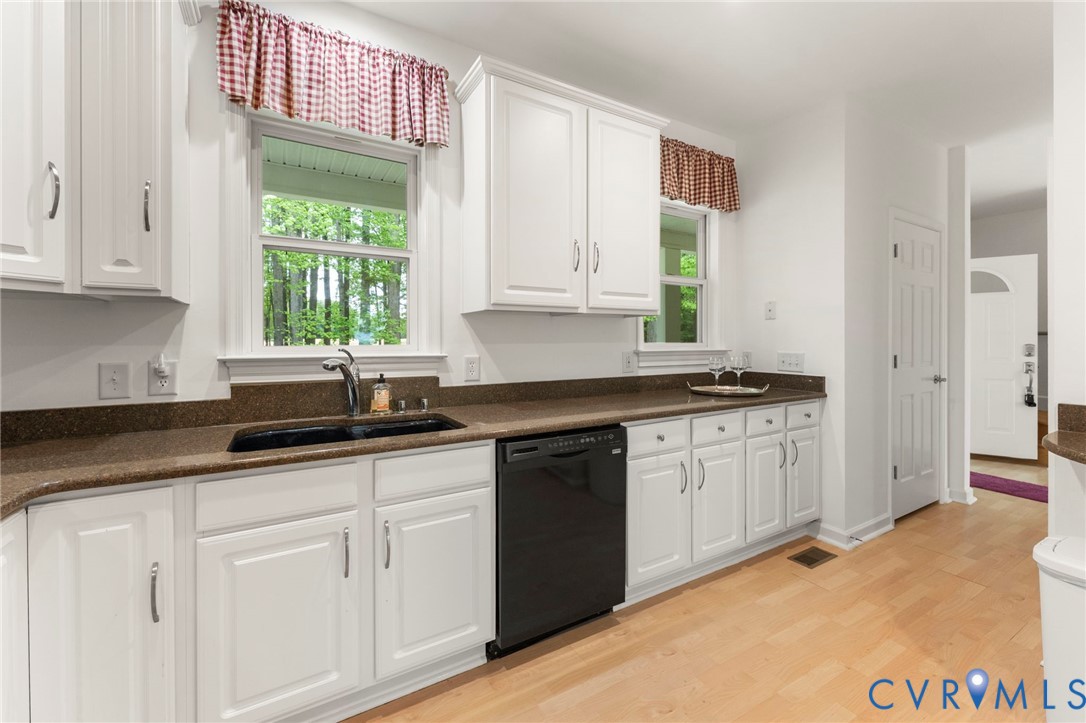 625 Whispering Pines Road Lancaster, VA 22503 - Photo 22 of 71 a kitchen with granite countertop white cabinets and a sink