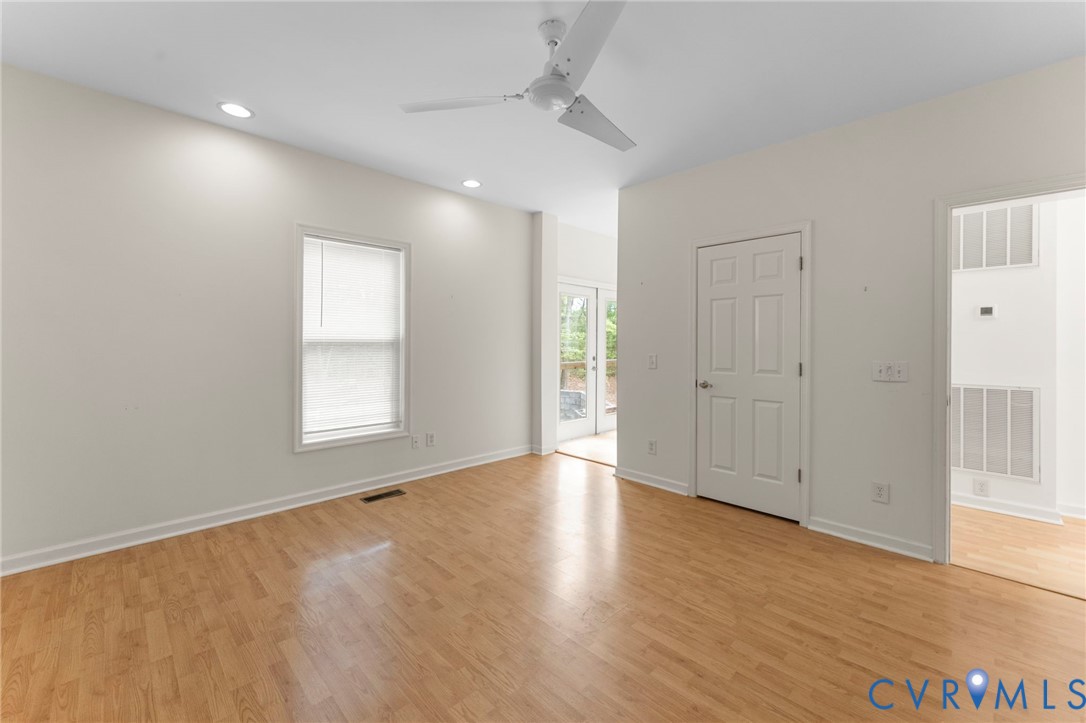 625 Whispering Pines Road Lancaster, VA 22503 - Photo 34 of 71 an empty room with wooden floor and windows