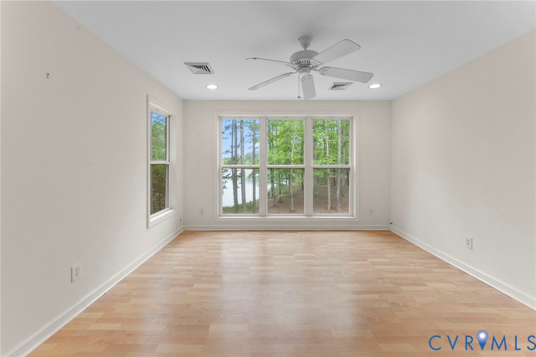 625 Whispering Pines Road Lancaster, VA 22503 - Photo 52 of 71 an empty room with chandelier fan and windows