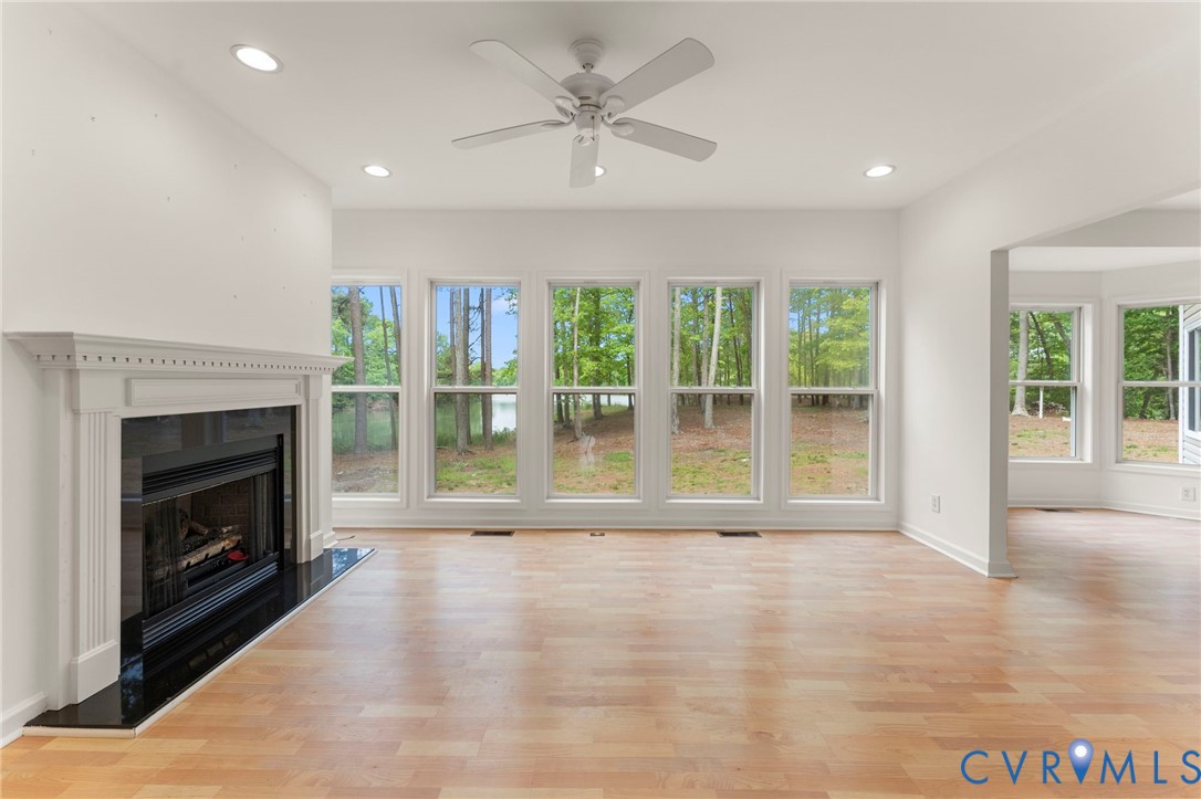 625 Whispering Pines Road Lancaster, VA 22503 - Photo 9 of 71 a view of an empty room with a fireplace and a large window