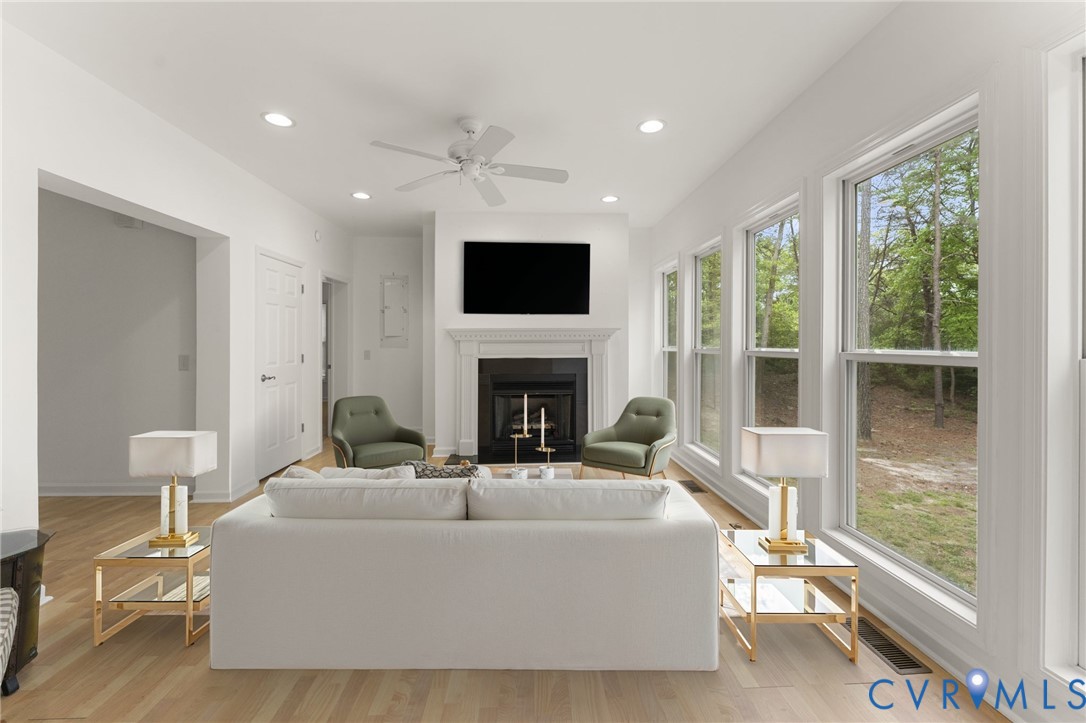 625 Whispering Pines Road Lancaster, VA 22503 - Photo 10 of 71 a living room with furniture a flat screen tv and a fireplace