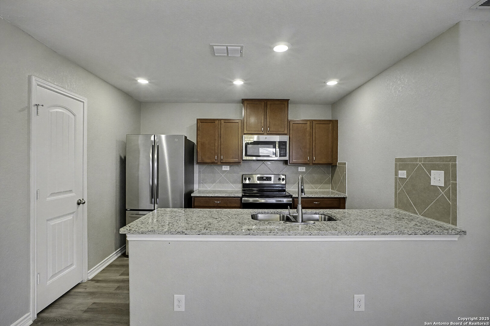 6508 Buffalo Ranch San Antonio, TX 78244 - Photo 12 of 31 a kitchen with stainless steel appliances granite countertop a sink and a refrigerator