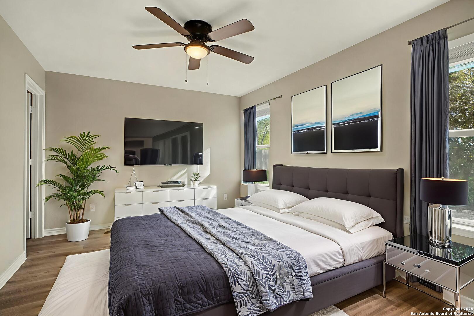 6508 Buffalo Ranch San Antonio, TX 78244 - Photo 15 of 31 a bedroom with a large bed a flat tv screen and a potted plant