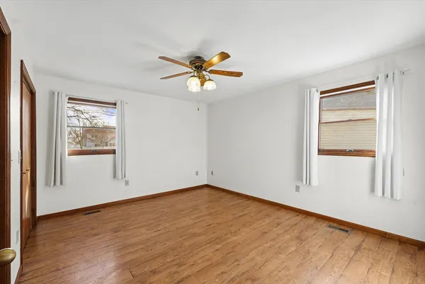 a view of an empty room with window and wooden floor