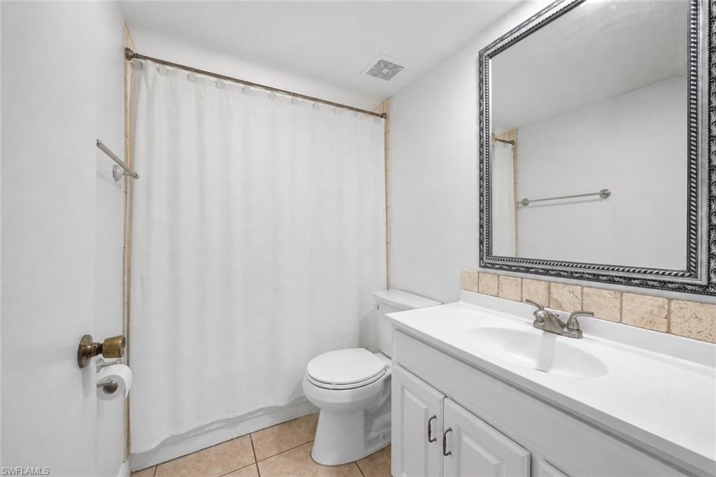 5737 Whitaker Road, Unit C101 Naples, FL 34112 - Photo 17 of 28 a bathroom with a granite countertop sink toilet and shower